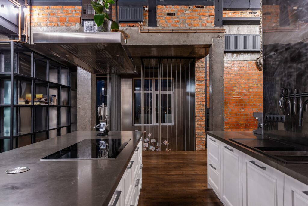 Interior of spacious kitchen area with modern furniture placed in luxury apartment in loft style